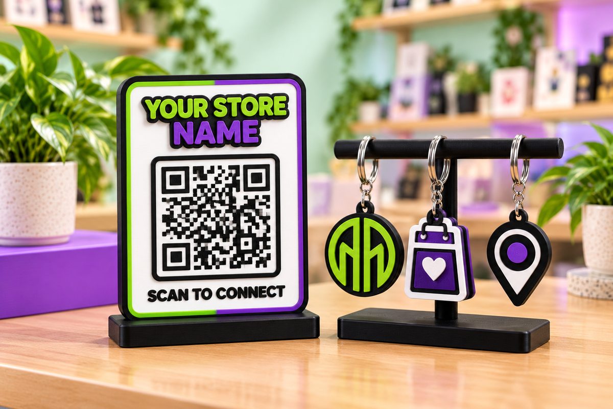 3D printed QR sign display with three matching branded keyrings on a stand